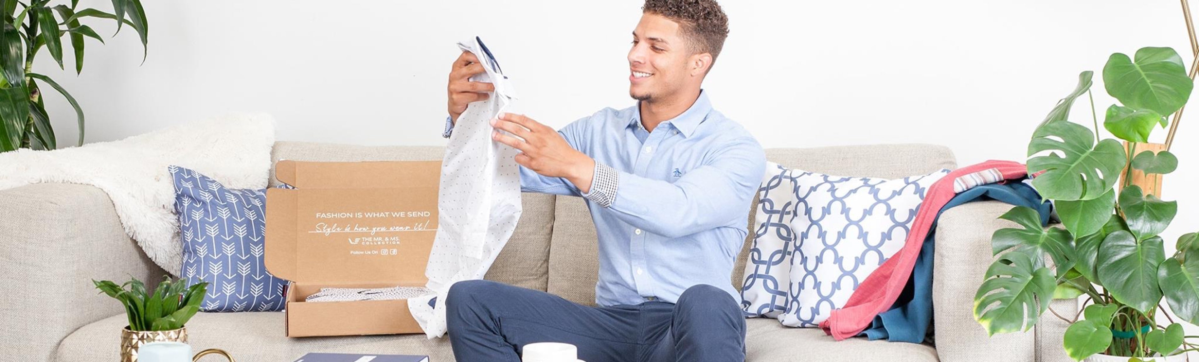 man opening a subscription box with clothes