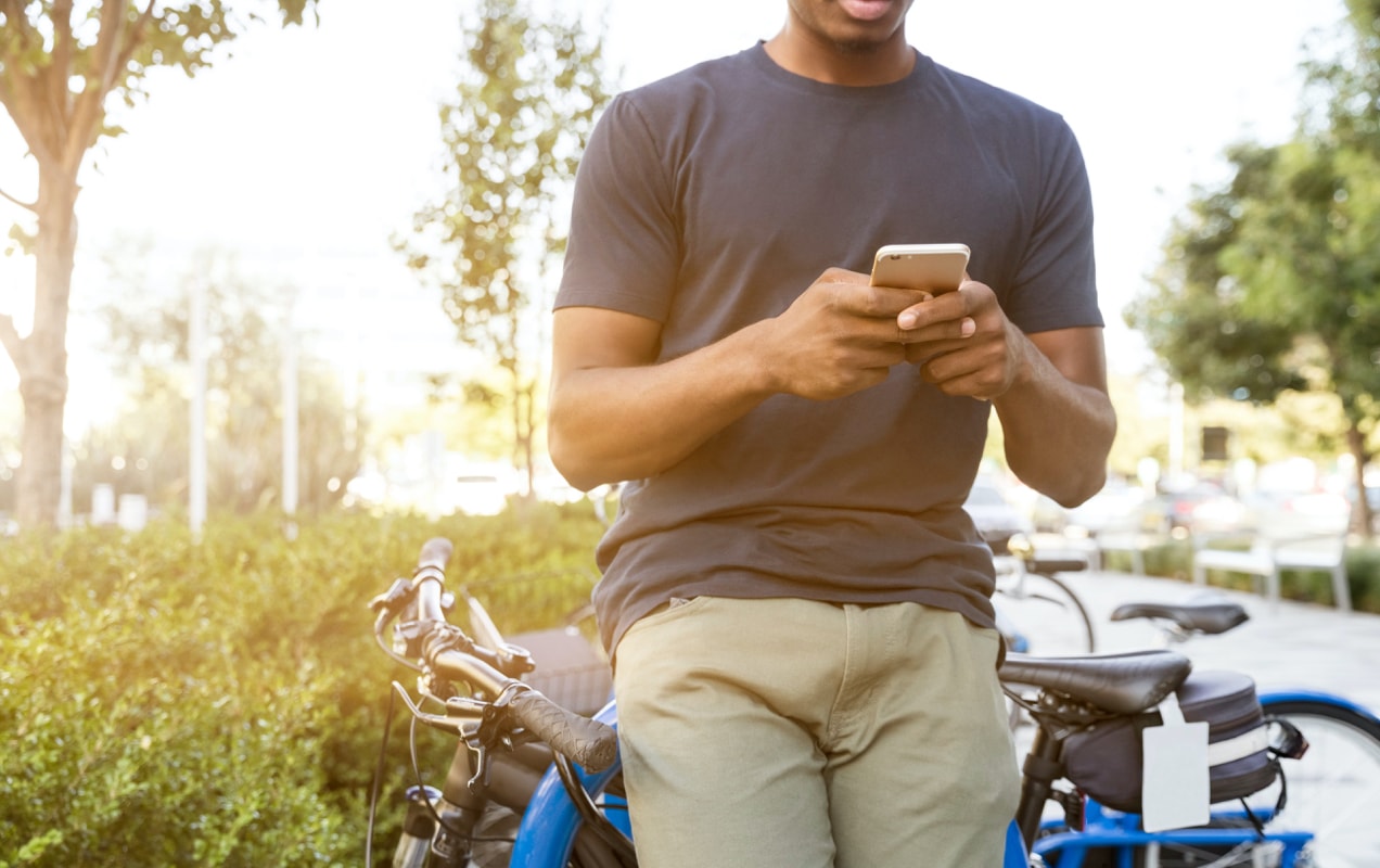man looking at his phone on a bike ride