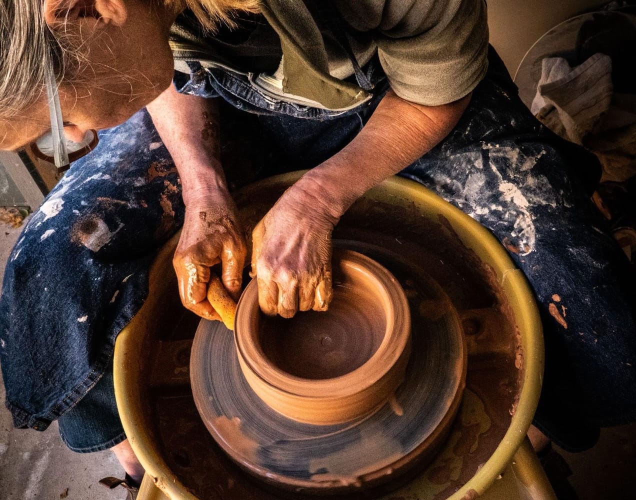 woman crafting pottery out of clay